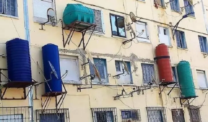 Citernes d'eau sur la façade d'un immeuble en Algérie.