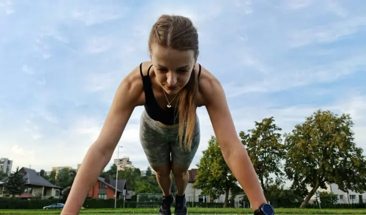 a woman is doing push ups in the grass