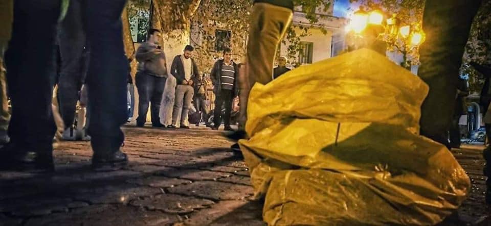 Des citoyens nettoient la place où s’est tenue la manifestation en soutien au pouvoir et à la présidentielle