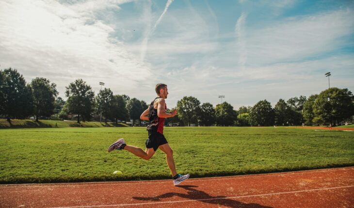 A man running across a field on a sunny day