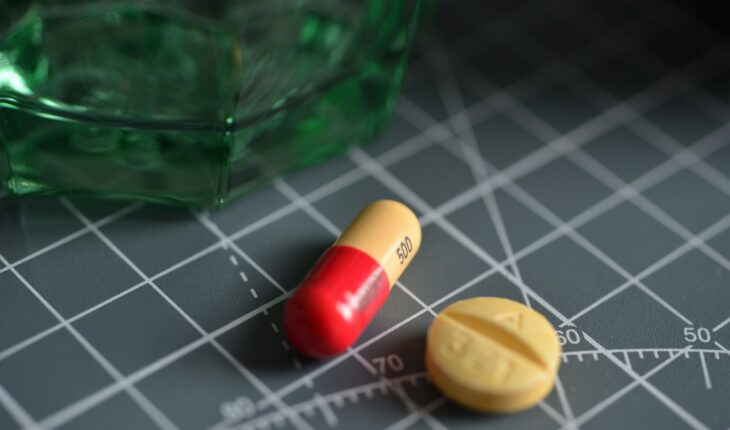 red and yellow medication pill on green glass bottle