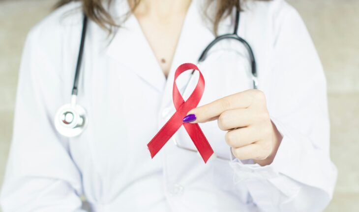 a woman in a white shirt holding a red ribbon