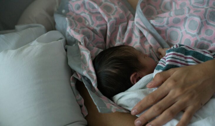 Mother holding a newborn baby while breastfeeding.