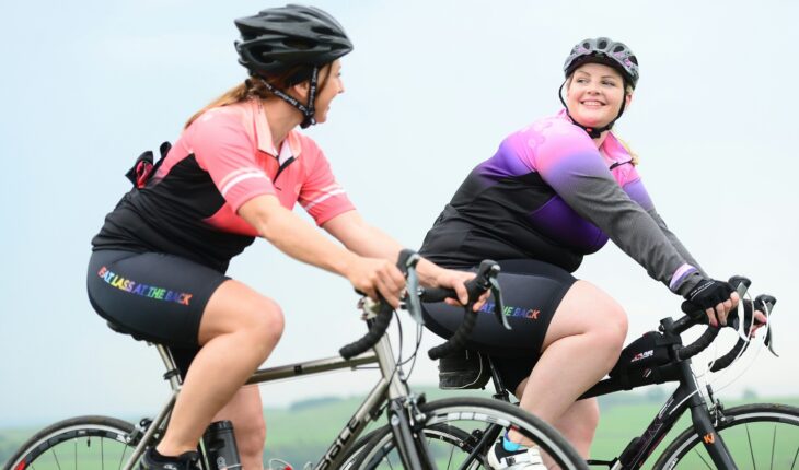 a couple of women riding on the back of bikes